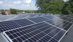 Zonnepanelen op het dak, en de windmolens in de verte. 100% hernieuwbare energie!